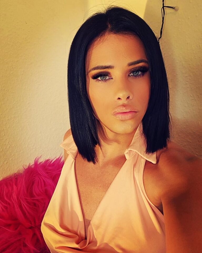 GianinaTS im Selfie mit sinnlichem Blick und beigen Dessous