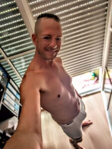 Larry Ragnarök Adler als glücklicher Wifesharer Sexperte im weißen Hugo Boss Boxer vor seiner Terrassentür. Analdominanz TS Kim Wagner