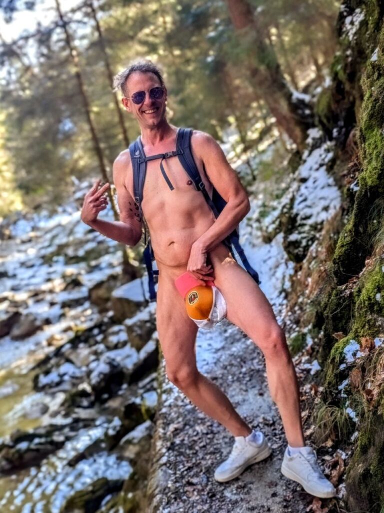Larry Ragnarök Adler liebt die Cowgirl-Stellung steht lachend nackt am Wanderweg im Jenbachtal, hält sein Cap vor seine intimsten Stellen – erfahrener Sexperte in der Natur. GianinaTS Fan Gianina