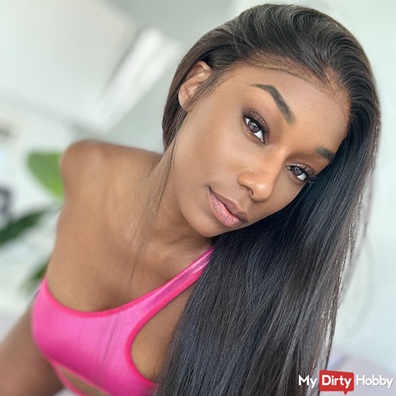 Nikimay, dunkelhäutiges Erotikmodel mit langen schwarzen Haaren, pinkem Sport-BH und verführerischem Lächeln auf GirlsHub