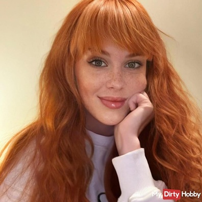 Soley Summer mit rotem Haar und verträumtem Blick stützt ihren Kopf auf die linke Hand – GirlsHub Erotikmodel