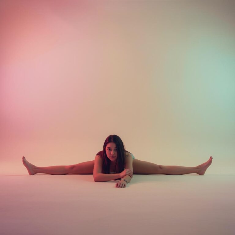 Person dehnt sich in Pastellkulisse bei sanfter Musik – Symbol für Dehnen und Flexibilität in der täglichen Routine.