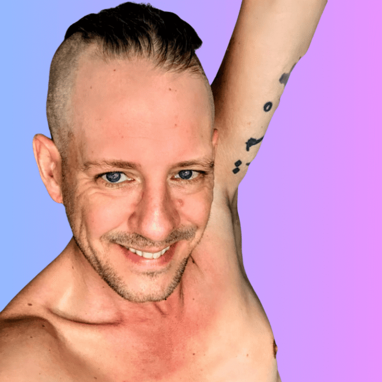 Larry Adler steht nackt vor dem Spiegel, zeigt blaue Augen, charmantes Gesicht und selbstbewusste, offene Sexualität in einem natürlichen Selfie.